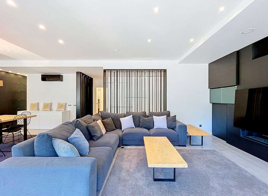 Experience modern living in this spacious open-concept living area, featuring a large sectional sofa perfect for gatherings.