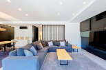 Experience modern living in this spacious open-concept living area, featuring a large sectional sofa perfect for gatherings.