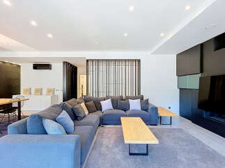 Experience modern living in this spacious open-concept living area, featuring a large sectional sofa perfect for gatherings.