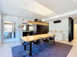 Experience modern living in this spacious dining area, featuring a large wooden table with contemporary wire chairs perfect for gatherings.