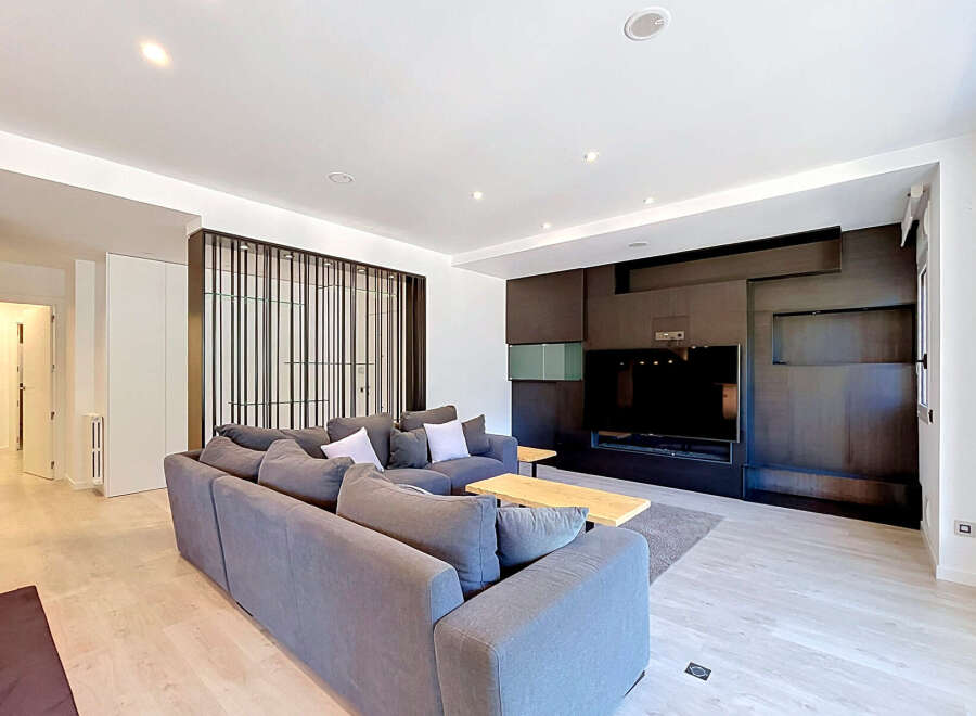 Experience modern living in this spacious living room, featuring a large, comfortable sectional sofa perfect for gatherings.
