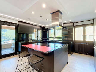 Experience modern luxury in this sleek, contemporary kitchen featuring a spacious island with a vibrant red countertop, perfect for meal prep and casual dining.
