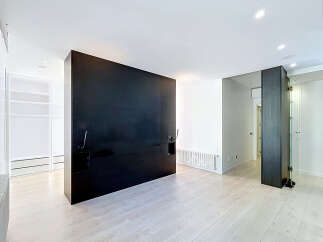 Experience modern living in this spacious room featuring a striking black headboard wall and sleek, minimalist design.