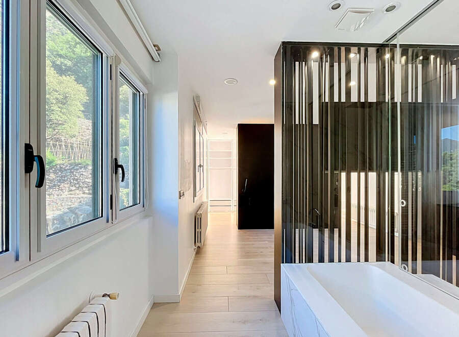 Experience modern living in this stunning hallway featuring large windows with scenic views and a sleek, contemporary design.