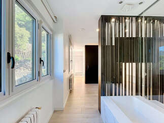 Experience modern living in this stunning hallway featuring large windows with scenic views and a sleek, contemporary design.