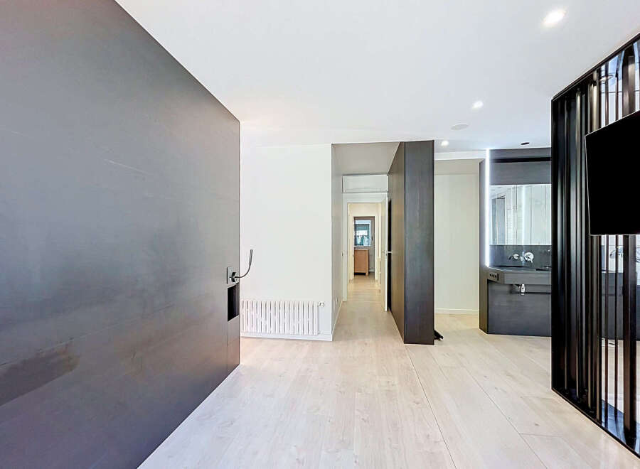 Discover modern living in this stylish apartment featuring a sleek, dark-toned feature wall and a minimalist aesthetic.