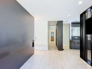 Discover modern living in this stylish apartment featuring a sleek, dark-toned feature wall and a minimalist aesthetic.
