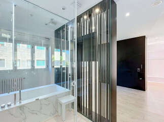 Experience modern luxury in this stunning bathroom featuring a sleek bathtub with marble accents and a contemporary faucet.