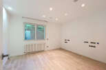 Discover this modern, empty room featuring a large window overlooking lush greenery, perfect for natural light.