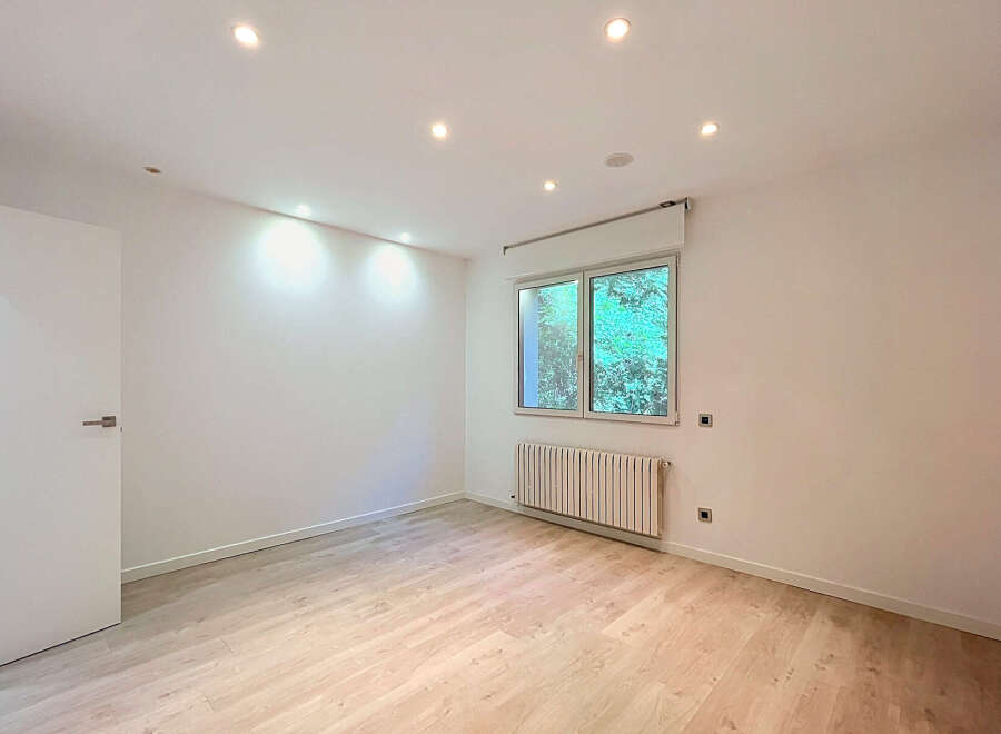 Discover this bright and airy room featuring a modern white door and a large window that floods the space with natural light.
