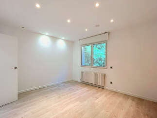 Discover this bright and airy room featuring a modern white door and a large window that floods the space with natural light.