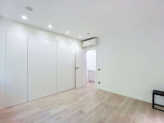 Discover this modern bedroom featuring a sleek, floor-to-ceiling white wardrobe providing ample storage.