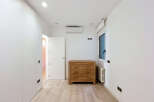Discover this bright and modern bedroom featuring a sleek white wardrobe and a charming wooden dresser.