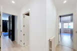 Step into this bright and airy hallway, featuring pristine white walls and elegant light wood flooring.
