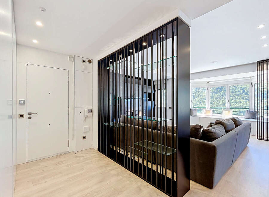 This modern apartment features a stylish entryway with a sleek white door and integrated storage.