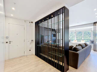 This modern apartment features a stylish entryway with a sleek white door and integrated storage.