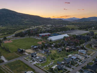 Experience luxury mountain living in this stunning aerial view of a modern residential development nestled against a scenic mountain backdrop.