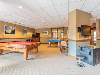 Enjoy endless entertainment in this game room, featuring a classic pool table and a fun foosball table.