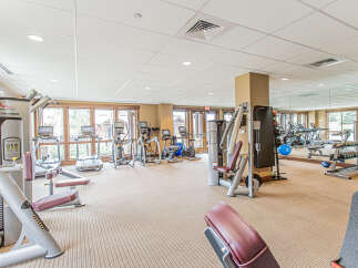 This spacious gym features a variety of modern exercise equipment, including treadmills, ellipticals, and weight machines, perfect for maintaining an active lifestyle.