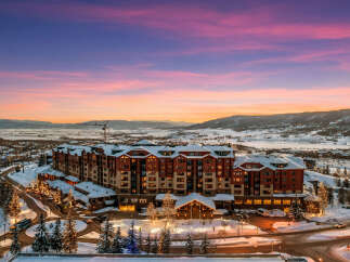 Experience luxury mountain living in this stunning ski resort property, bathed in the warm glow of a vibrant sunset.