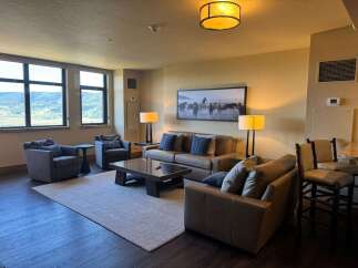 Experience luxurious living in this spacious great room, featuring comfortable seating arrangements and a stunning landscape artwork.