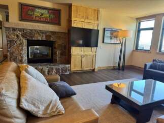 Cozy living room featuring a stone fireplace and a large leather sofa, perfect for relaxing evenings.