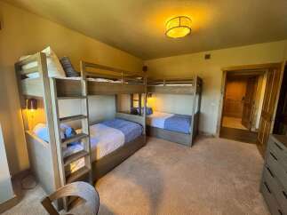 This spacious bedroom features two sets of bunk beds, perfect for accommodating family or guests.