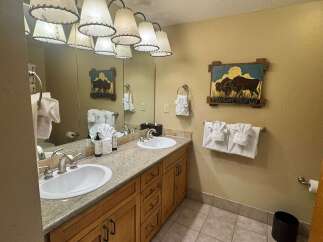 This charming bathroom features a dual-sink vanity with granite countertops, offering ample space for morning routines.