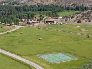 Discover this expansive ranch property featuring a private tennis and pickleball court, perfect for recreation and fitness enthusiasts.