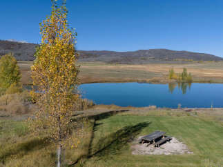 Experience the tranquility of this picturesque property, featuring a serene blue lake perfect for reflection and relaxation.