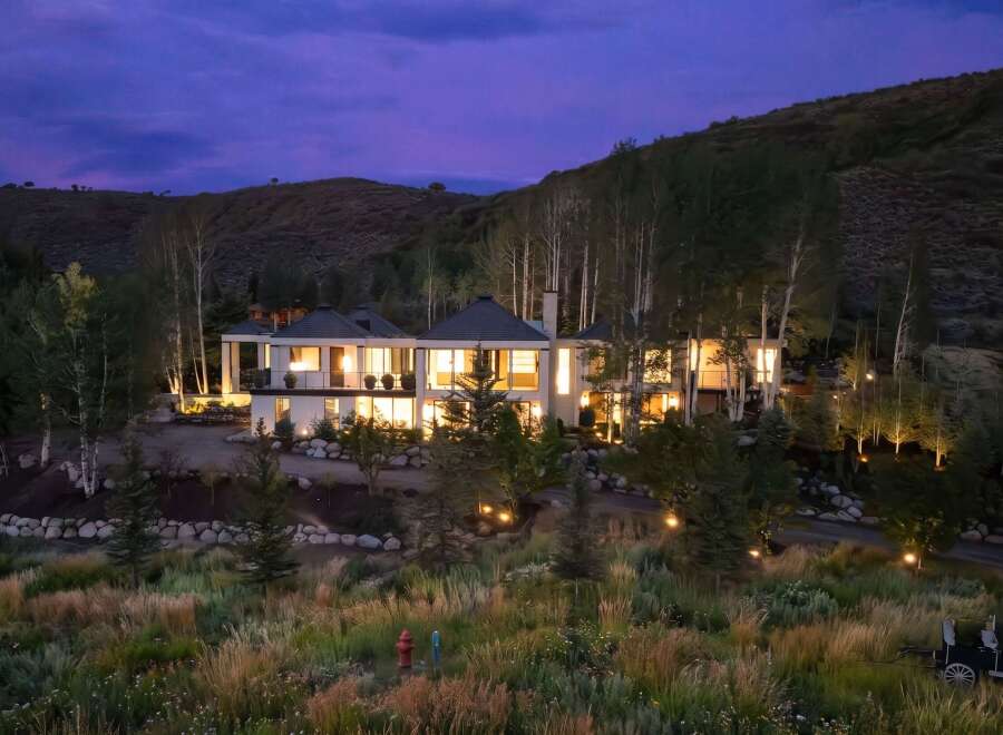 Experience luxury living in this stunning modern estate nestled against a picturesque hillside.