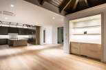 Experience modern luxury in this spacious open-concept living area, featuring a sleek dark wood kitchen with a central island and marble countertops.