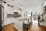 Experience luxury living in this stunning modern kitchen, featuring sleek white cabinetry, granite countertops, and a spacious island perfect for entertaining.