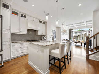 Experience luxury living in this stunning modern kitchen, featuring sleek white cabinetry, granite countertops, and a spacious island perfect for entertaining.