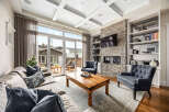Experience luxury living in this stunning living room featuring a floor-to-ceiling stone fireplace and a large entertainment system.