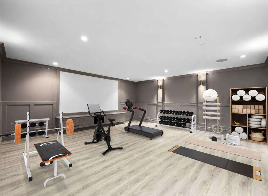 Elevate your fitness routine in this well-appointed home gym, featuring a Peloton bike, treadmill, and a complete weight set with a bench.