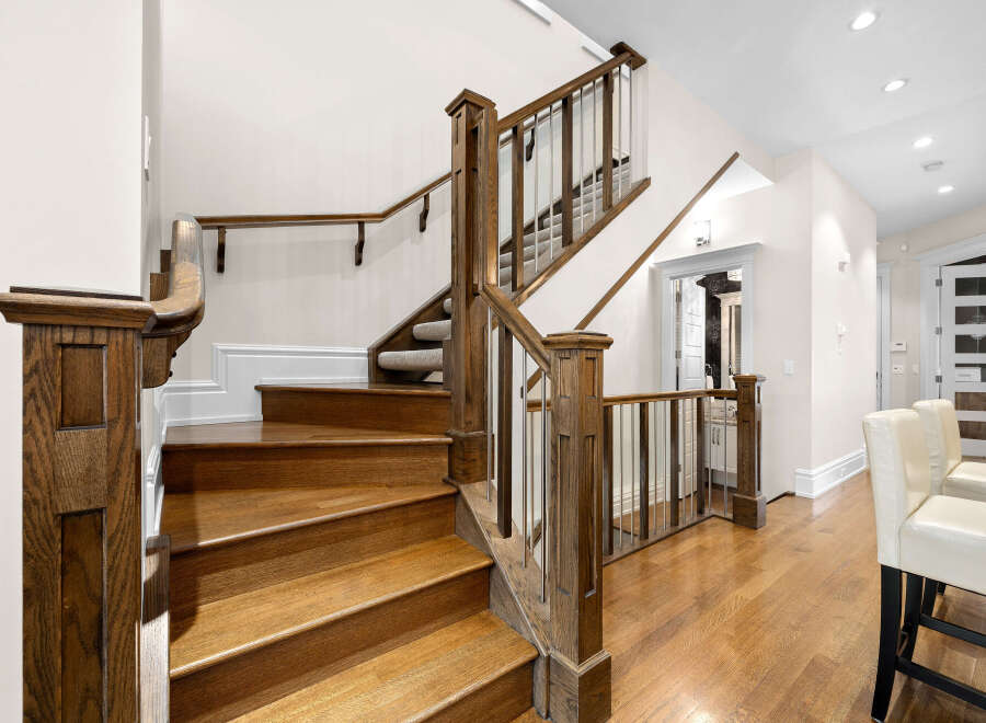 Experience elegance and craftsmanship with this stunning staircase, featuring rich hardwood treads and a sophisticated railing system.