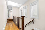 This spacious hallway features a beautiful wooden staircase with a dark wood banister and white spindles, leading to a bright upper level.