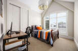 This charming bedroom features a comfortable bed with a colorful quilt, perfect for a cozy retreat.