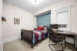 This charming bedroom features a comfortable bed with a colorful striped quilt, perfect for a cozy retreat.