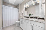 This modern bathroom features a spacious double vanity with a granite countertop and sleek chrome fixtures, perfect for busy mornings.