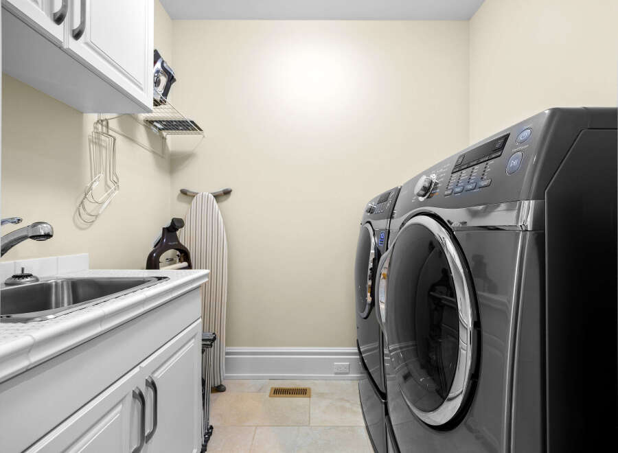 This laundry room features a spacious sink and ample cabinet space for storage.