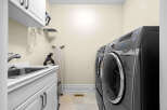 This laundry room features a spacious sink and ample cabinet space for storage.