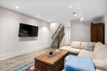 This basement living area features a large sectional sofa perfect for relaxing and entertaining.