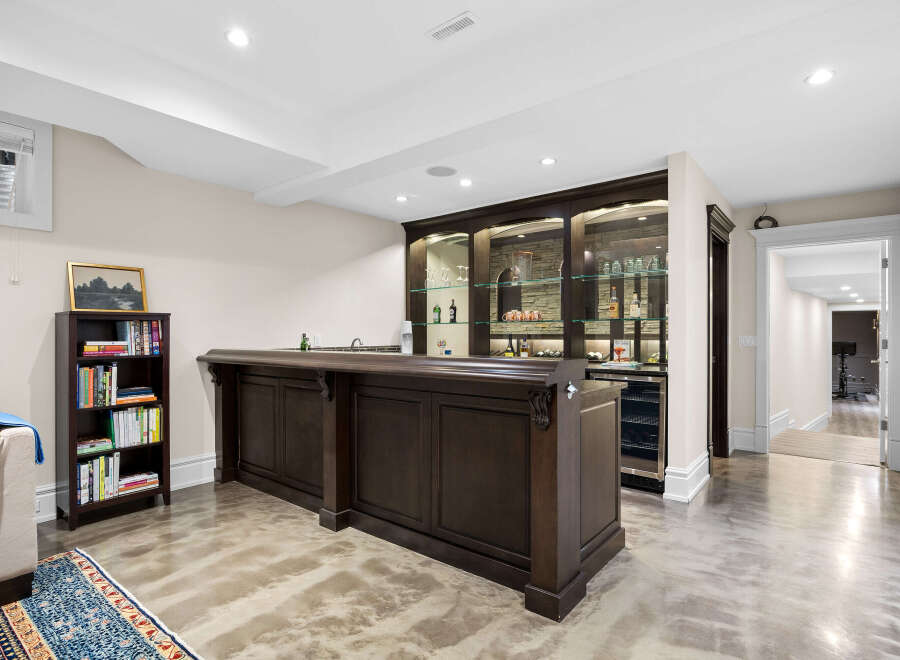 This finished basement features a stunning dark wood bar with a granite countertop, perfect for entertaining.