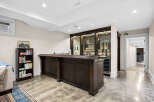 This finished basement features a stunning dark wood bar with a granite countertop, perfect for entertaining.