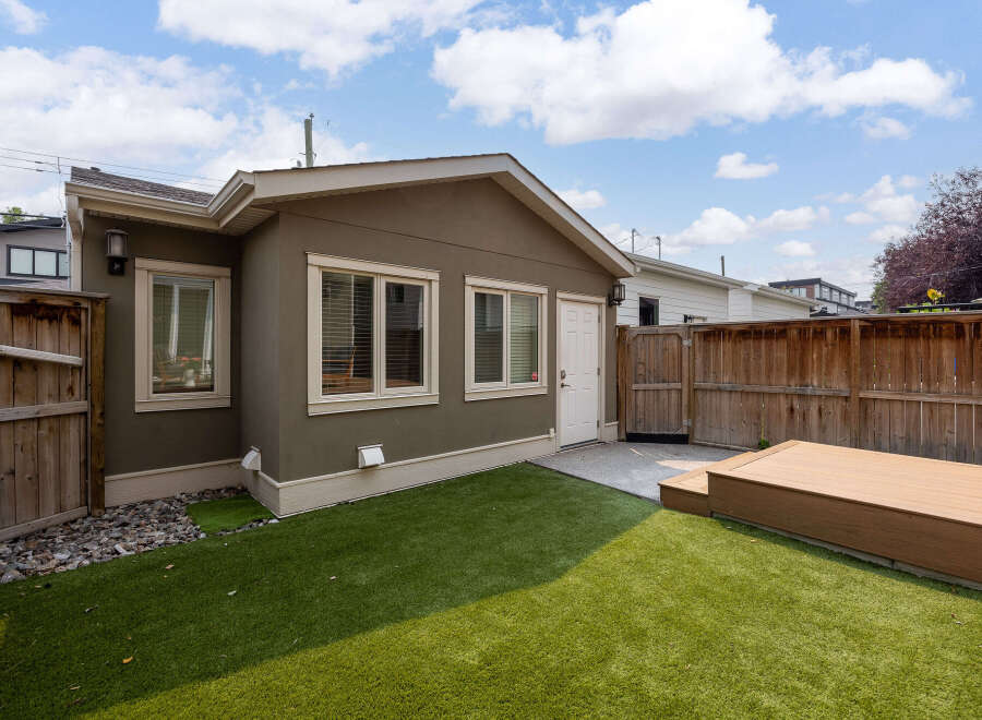 Enjoy this charming backyard oasis featuring a spacious artificial turf lawn perfect for play and relaxation.