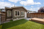 Enjoy this charming backyard oasis featuring a spacious artificial turf lawn perfect for play and relaxation.