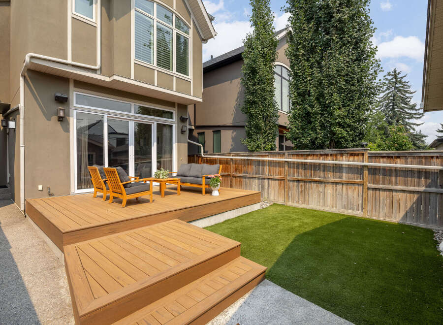 Step outside to a beautifully designed backyard featuring a multi-level wooden deck perfect for entertaining.