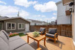 Enjoy outdoor living in this spacious backyard featuring a large wooden deck perfect for entertaining.
